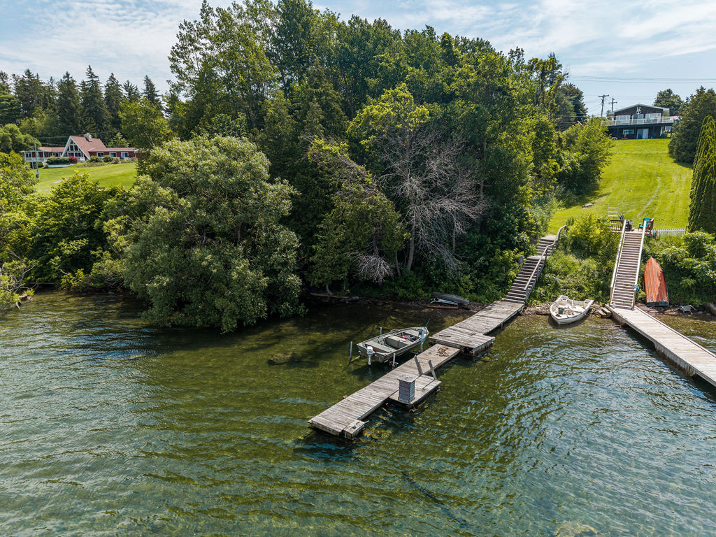Private dock reaching into the St. Lawrence River with boats moored