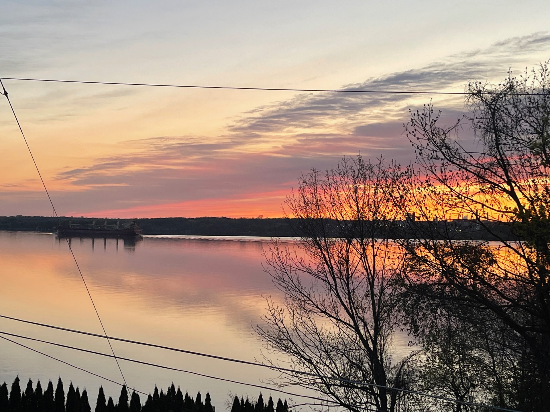 Fiery sunset over the St. Lawrence River with a passing ship