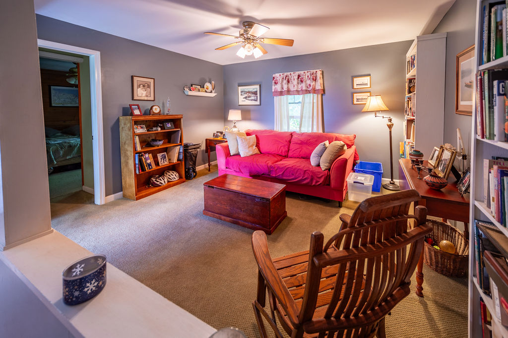 Sitting room with bookshelves and view into a bedroom