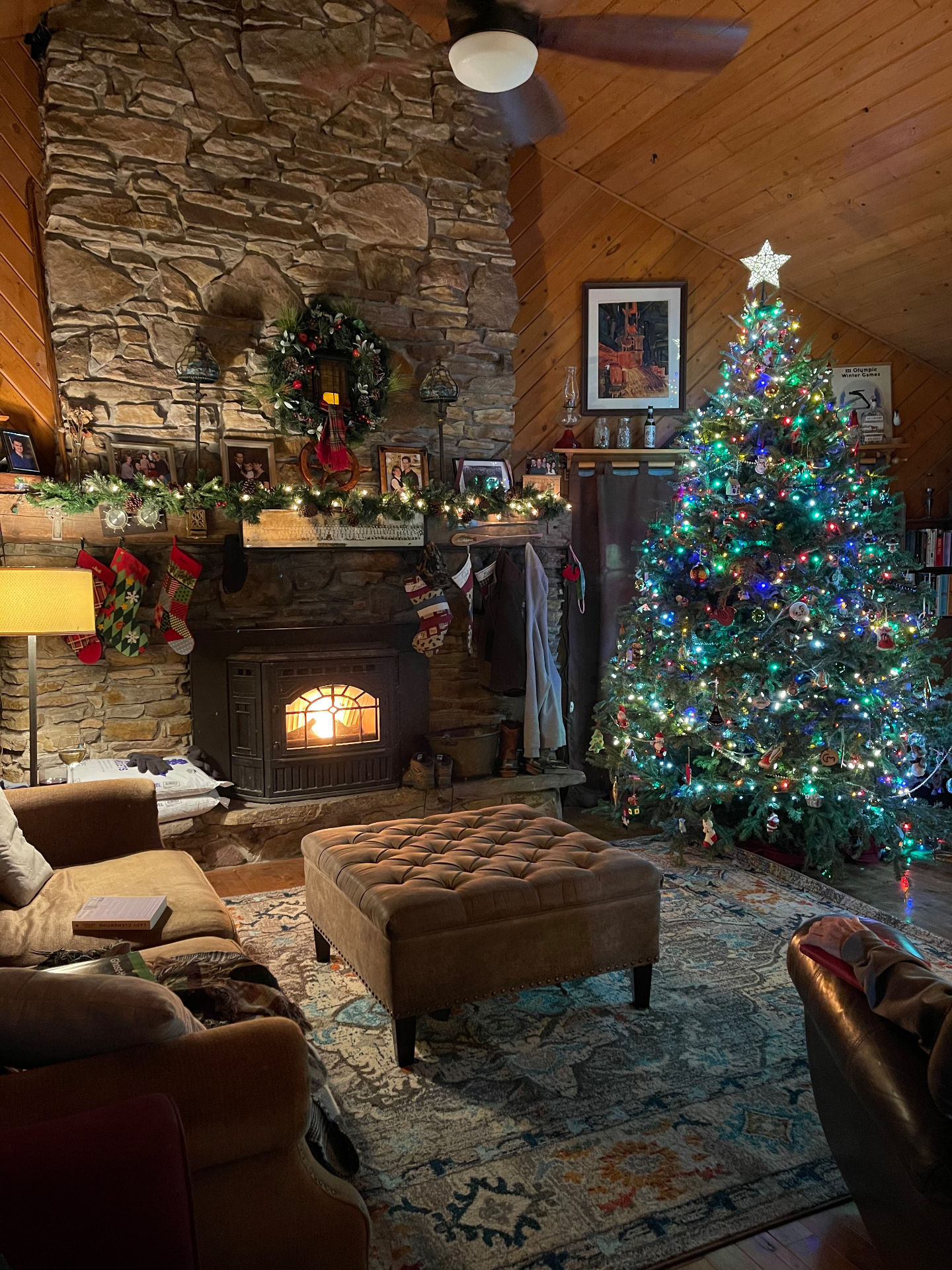 Cozy living room with stone fireplace and lit Christmas tree