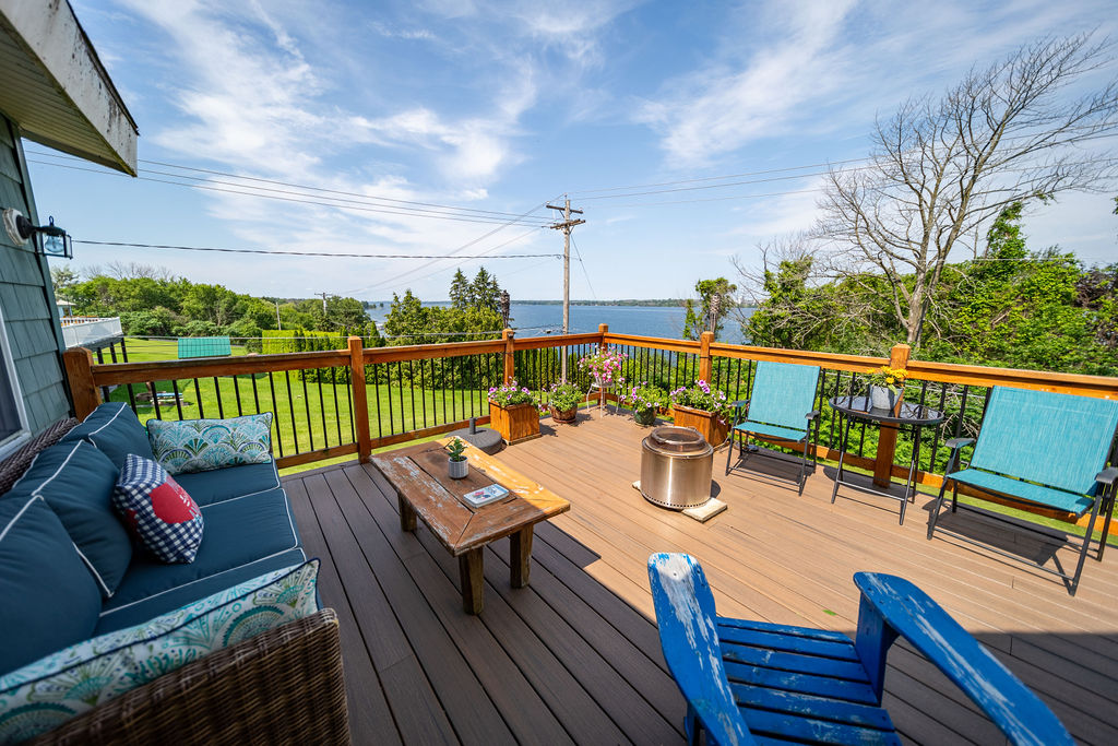 Expansive deck with lounge seating and panoramic St. Lawrence River views