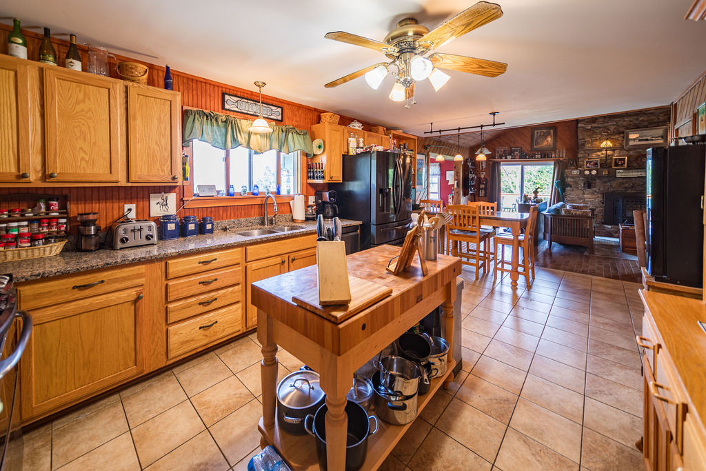 Kitchen open to the dining area and stone-fireplace living room