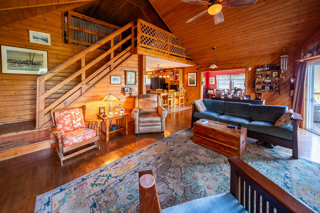 Living room looking up to the loft with wood staircase and vaulted ceiling