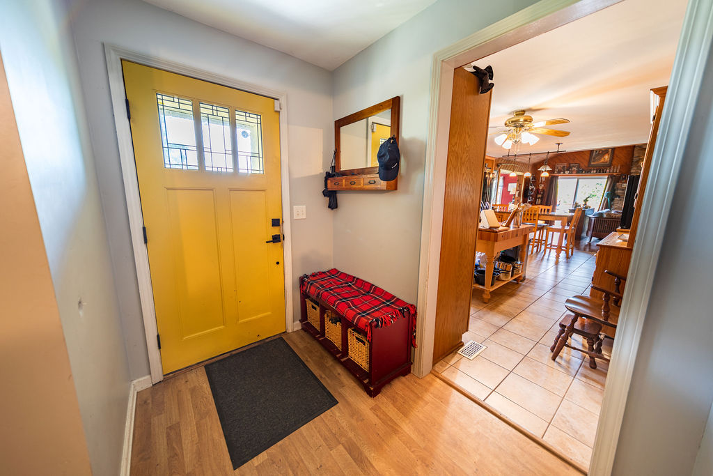 Bright entryway with yellow front door leading to the kitchen