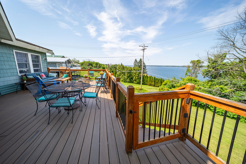 Wraparound Trex deck with dining set overlooking the water